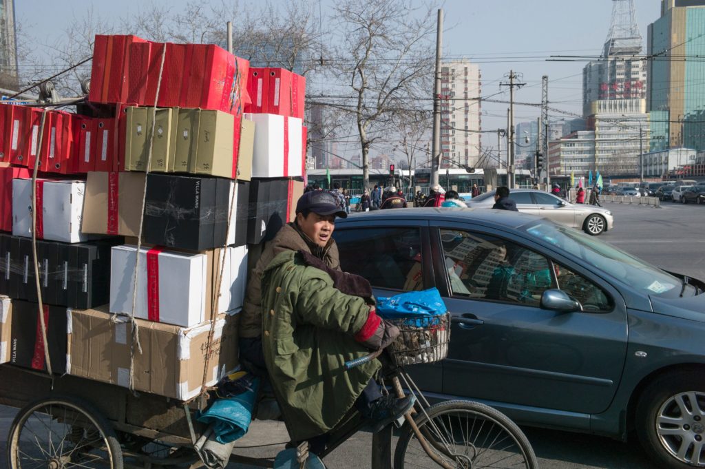 A man delivers goods in the street of Beijing on January 19, 2016. China's economy grew at its slowest pace in a quarter of a century last year as it undergoes a difficult transition, data showed on January 19, escalating concern over a crucial driver of global expansion.